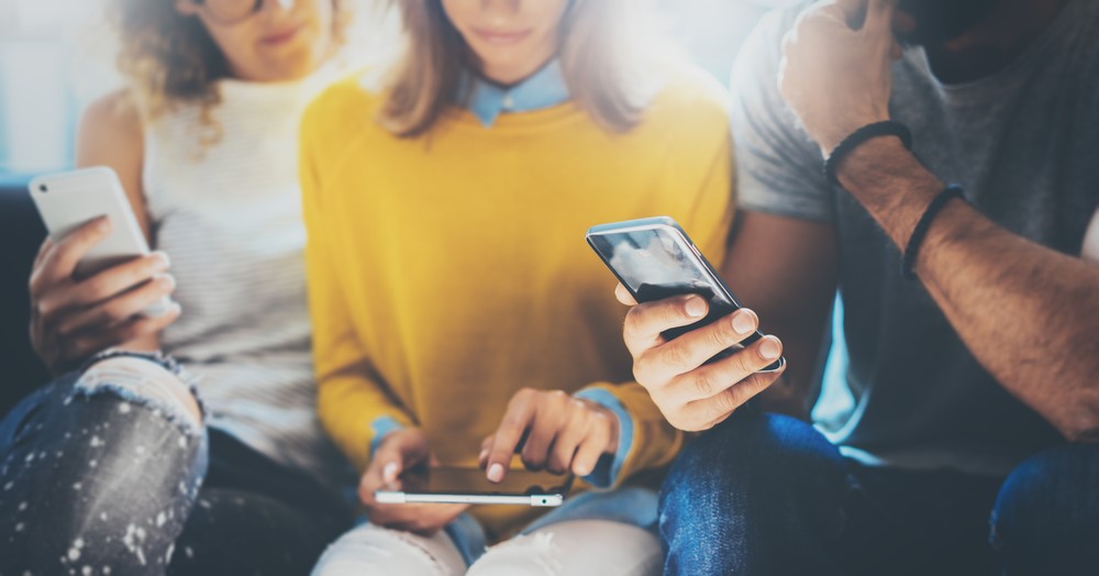 Pessoas discutindo negócios por meio de telefones celulares e tablets.