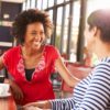 Woman laughing during a discussing with friend.