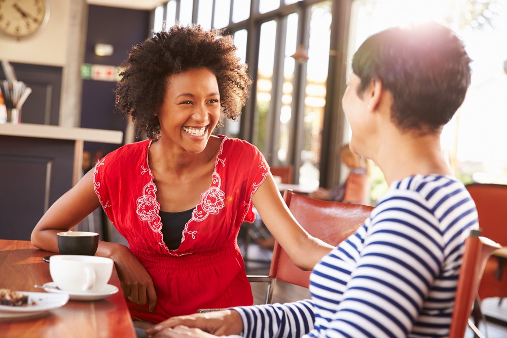 Woman laughing during a discussing with friend.